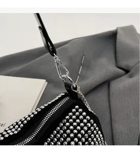 Close-up of polished silver hardware and chain on a black rhinestone evening bag