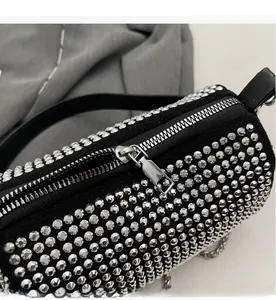 Close-up of smooth silver zipper and shiny rhinestones on black cylinder pillow bag