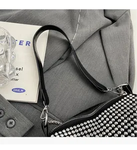 Detailed close-up of a black crossbody bag featuring dense silver dome stud rivets