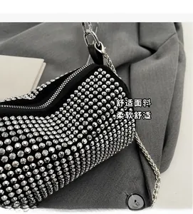 Detailed macro view of black barrel bag with dense silver rhinestones and metal chain