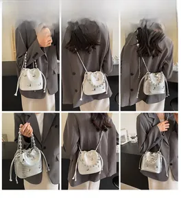 Detailed views of drawstring bucket bag with butterfly decor and beaded handle on a model