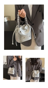 Detail of silver bucket bag with metal butterfly accents and beaded chain handle
