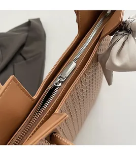 Gros plan sur la fermeture éclair en métal et la texture tissée avec foulard en soie