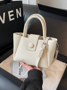 Chic beige lychee leather bucket handbag with top handle and crossbody strap for women