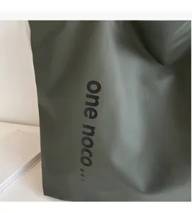 Detail of dark green tote bag featuring high-quality leather texture and branding