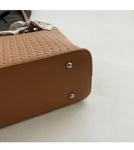 Gros plan du fond tressé marron d'un cabas avec clous de protection en métal