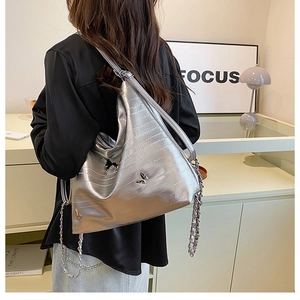Dettaglio della borsa tote argento metallizzato con trama a coccodrillo su modella