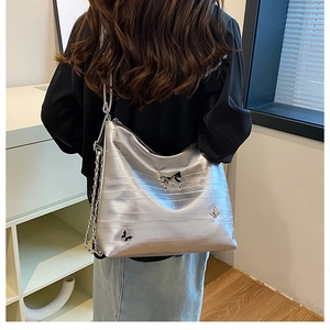Dettaglio della borsa hobo argento con finitura testurizzata e tre farfalle metalliche