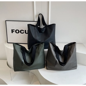 Detailed trio of large nylon tote bags in black, olive green, and dark grey with logo