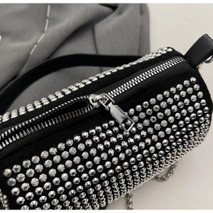 Close-up of sparkling rhinestone handbag with silver metal zipper and chain detail