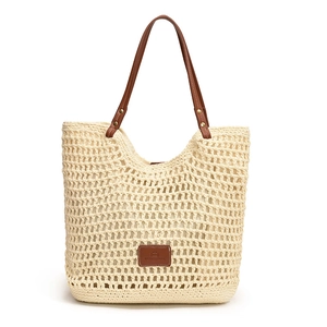 Beige hollow woven tote bag with brown leather handles and inner lining for beach