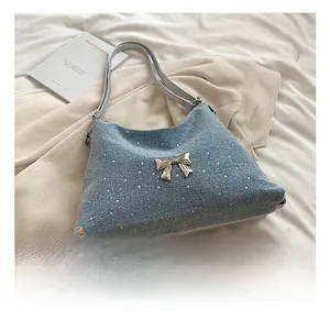 Dettaglio della borsa denim blu con strass scintillanti e fibbia a fiocco d'oro