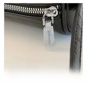 Close-up of smooth silver metal zipper with engraved text on sleek black pillow bag