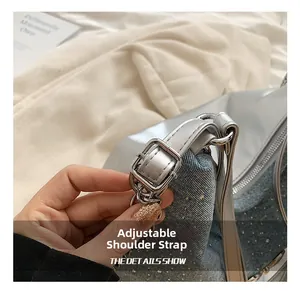 Dettaglio della fibbia regolabile in argento e del tessuto denim sulla borsa tote