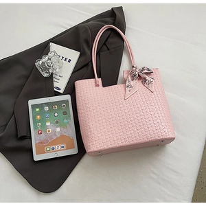 Sac fourre-tout tissé rose avec foulard floral et rivets de protection sur le fond