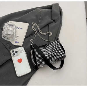 Detailed close-up of sparkling black rhinestone bucket bag with silver metal chain
