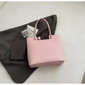 Vue détaillée du sac cabas rose tissé avec rivets de protection et poignées solides