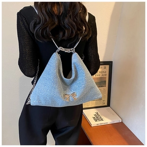 Dettaglio borsa tote azzurra glitterata con fiocco argento e tracolla a catena metallica
