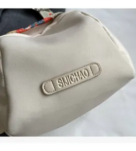 Close-up of ivory canvas bag texture with ethnic style printed strap and logo detail