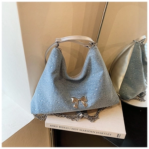 Dettaglio della borsa tote in denim azzurro con strass luccicanti e fiocco in argento