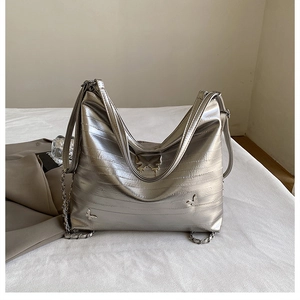 Dettaglio della borsa hobo argento con farfalle metalliche e tracolla a catena