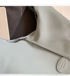Macro detail of silver metal zipper and lychee grain leather on mint green bag
