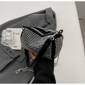 Detailed view of black cylinder bag with sparkling silver rhinestones and metal chain