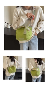 Detail view of grass green nylon shell bag with floral embroidered wide strap