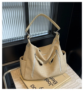 Detailed view of a beige woven tote bag with silver zippers on a recipe book