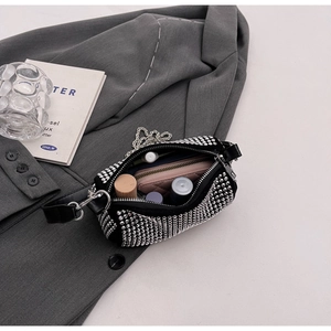 Detailed view of rhinestone cylinder bag interior showing storage space and accessories
