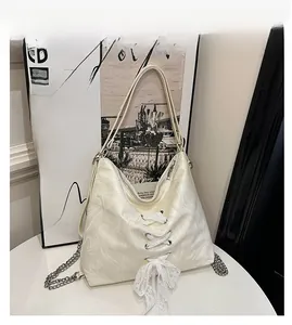 Close-up of cream marble print tote with lace-up detail and silver metal chain strap