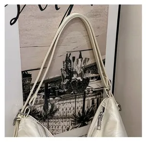 Detail of cream white textured leather shoulder bag with stylish dual strap and silver zipper