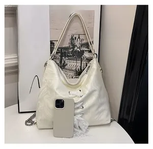 Detailed close-up of white Hobo bag with lace ribbon decor and phone for size comparison