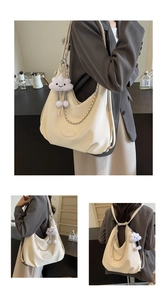 Detail of off-white dumpling bag with silver chain and plush cloud charm accessory