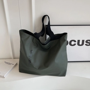 Minimalist large dark green nylon tote bag for women featuring wide black shoulder straps
