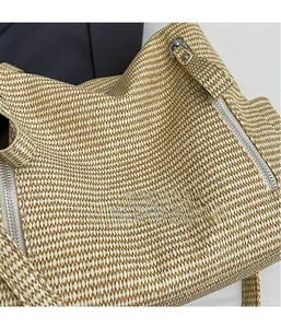 Close-up of beige woven tote bag showing 3D herringbone texture and silver zipper