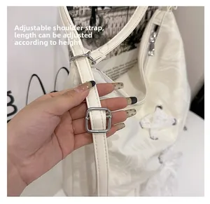 Detail of adjustable cream PU bag strap with silver metal buckle and lace-up texture