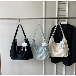 Three minimalist half-moon tote bags in black, blue, and beige with cloud charms
