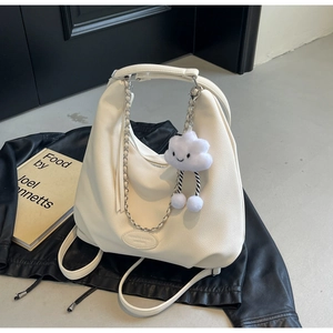 Detail of off-white hobo bag with litchi grain texture, chain strap and cloud charm