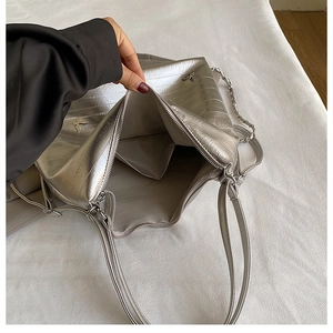 Dettaglio della borsa tote argento con decorazione a farfalla e chiusura a zip