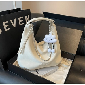 Detail of off-white lychee leather hobo bag with silver chain and plush cloud charm