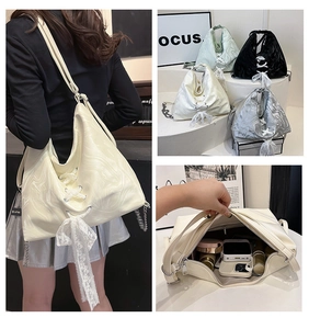 Detail of ripple texture tote bag featuring a lace bow and chain strap design