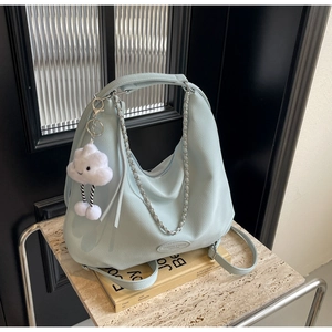 Detail of mint green pebbled leather hobo bag with silver chain and cloud charm