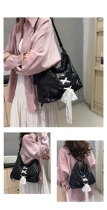 Detail of black marble pattern tote with white lace bow and silver metal chain strap