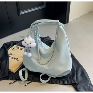 Macro shot of mint green lychee textured leather bag with silver chain and white cloud charm