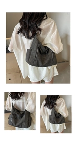 Detailed view of woven hobo bag featuring vertical silver zippers and thick shoulder strap