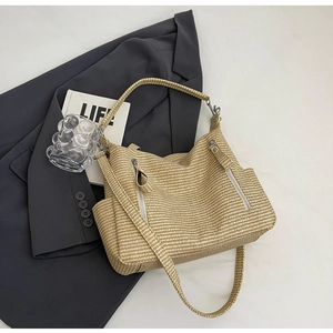 Detailed close-up of woven tote bag texture with decorative zipper and side pocket