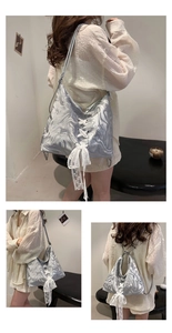 Macro shot of silver marble texture bag with white lace bow and metal chain detail