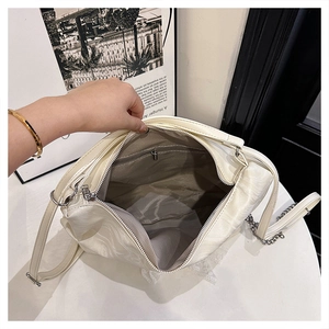 Detail view of large cream tote bag interior with high quality silver chain and lining