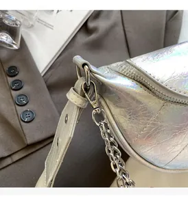 Détail de la chaîne argentée et de la texture irisée sur un sac bandoulière moderne